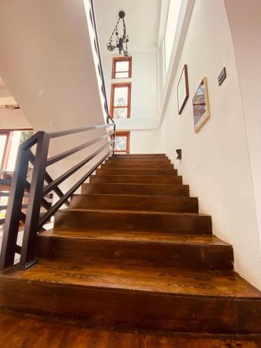a staircase in a house with wooden floors and a railing at nuwaraelliya euphoria white house in Nuwara Eliya