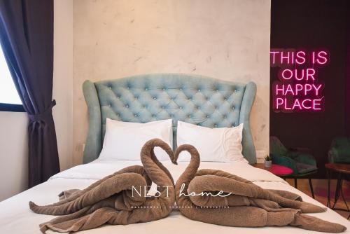 a bed with two towels in the shape of a heart at Twin Tower Residence by Nest Home【5 mins walk to CIQ】 in Johor Bahru