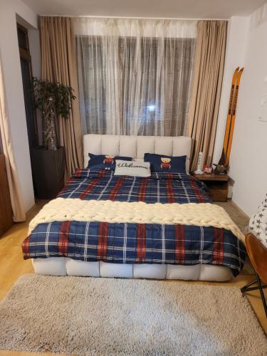 a bedroom with a large bed with a plaid blanket at BH and Semiramida Ski Apartment in Borovets