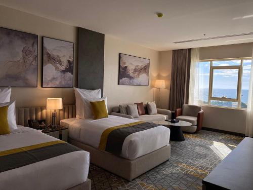 ウムラッジにあるEnala Hotel- Umlujのベッド2台とソファが備わるホテルルームです。