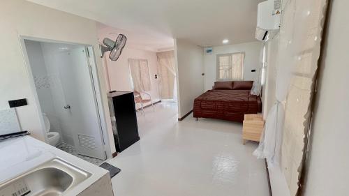 ein Schlafzimmer mit einem Bett und einem Waschbecken in einem Zimmer in der Unterkunft Aiem-Wilai Guesthouse in Surat Thani
