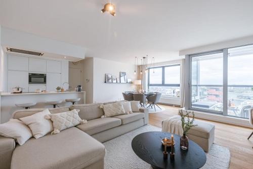 a living room with a couch and a table at Huswell - Apartment with beautiful view of Antwerp in Antwerp