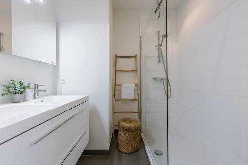a white bathroom with a sink and a shower at Huswell - Apartment with beautiful view of Antwerp in Antwerp