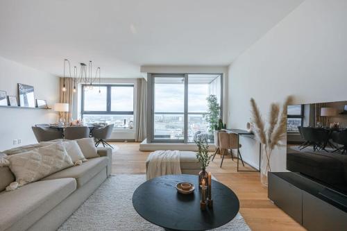 a living room with a couch and a table at Huswell - Apartment with beautiful view of Antwerp in Antwerp