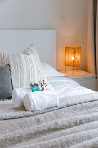 a bedroom with a white bed with towels and a lamp at Huswell - Apartment with beautiful view of Antwerp in Antwerp