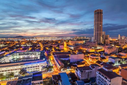 un skyline della città di notte con un grattacielo alto di MyHome Batu Feringghi Penang a Batu Ferringhi