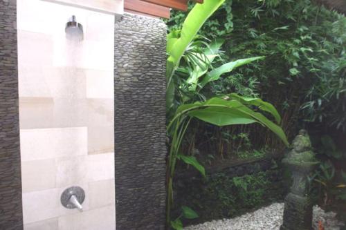 a bathroom with a stone wall and a fountain at Jungle Villa! Breath-taking views & near Ubud! in Penginyahan