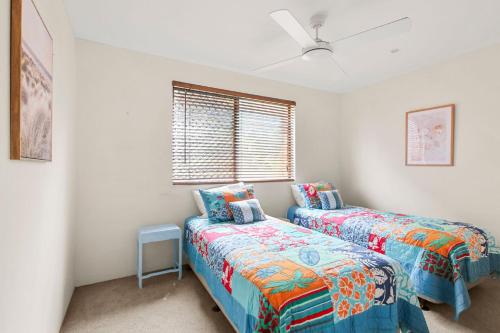a bedroom with two beds and a window at Island View Unit 3, 23 Esplanade, Bulcock Beach in Caloundra