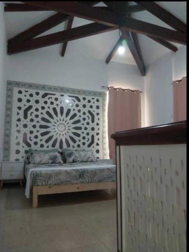 a bedroom with a bed with a stenciled wall at Villa Marame in Bordj el Bahri