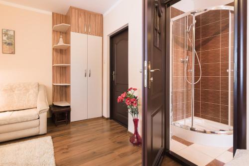 een badkamer met een douche en een vaas met bloemen bij Pokój u Zosi in Zakopane