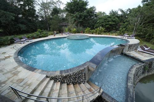 una piscina con terraza de madera y piscina en Siddhartha Vilasa Banbas, Chitwan, en Chitwan