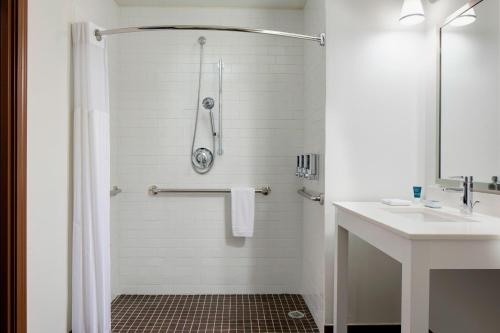 a white bathroom with a shower and a sink at Four Points by Sheraton Dallas Fort Worth Airport North in Coppell