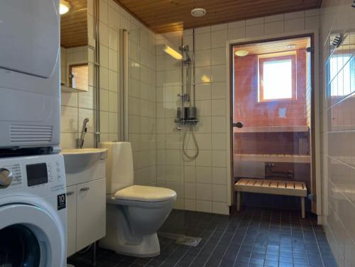 a bathroom with a toilet and a washing machine at 3h + k Golfkentän vieressä in Vantaa
