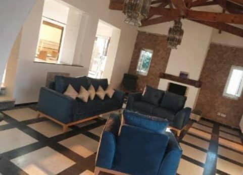 a living room with two blue couches and a fireplace at Villa Marame in Bordj el Bahri