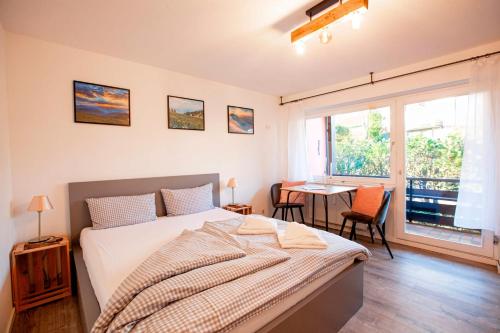 a bedroom with a bed and a desk and a window at FeWo Allgäuzeit mit WLAN Oberstaufen Steibis in Oberstaufen