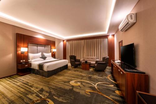 Cette chambre comprend un lit et une télévision à écran plat. dans l'établissement Msharef almoden hotel فندق مشارف المدن, à Abha