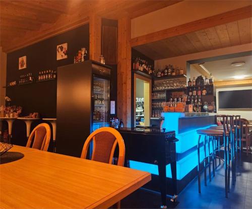 a bar with wooden tables and chairs in a restaurant at Garni Unterwegguetl in Naturno