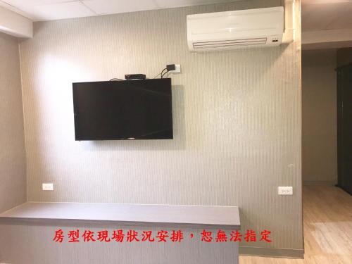 a flat screen tv on the corner of a wall at My House Hotel in Luodong