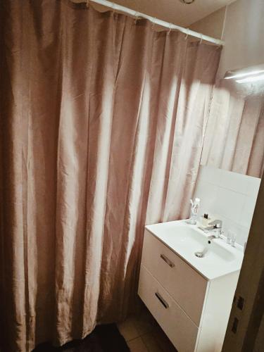 baño con lavabo y cortina de ducha en Chambre d'Hôtes calme et cosy, à 3min de la gare, centre ville, avec un lit de 160cm, en Nevers