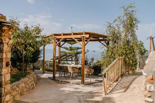 a wooden pergola with a table and chairs under it at Perivolakia Panorama House in Perivolákia
