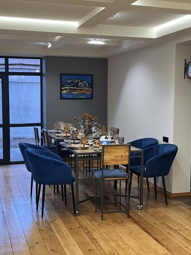 a dining room with a table and blue chairs at Arevaham Boutique Hotel in Stepʼanavan