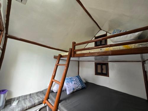 a bunk bed in a room with a ladder at Kua's Pad Batangas Kubo in Lian