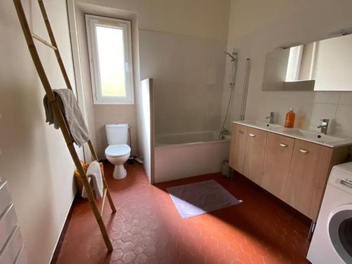 une salle de bain avec une baignoire, des toilettes et un lavabo dans l'établissement T3 rénové dans une maison de ville, à Marseille