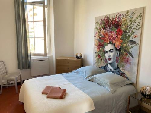 une chambre avec un lit avec un tableau sur le mur dans l'établissement T3 rénové dans une maison de ville, à Marseille