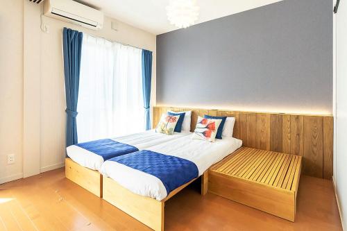 a bedroom with a large bed with blue and white sheets at Chura Minpaku Ishigaki in Ishigaki Island