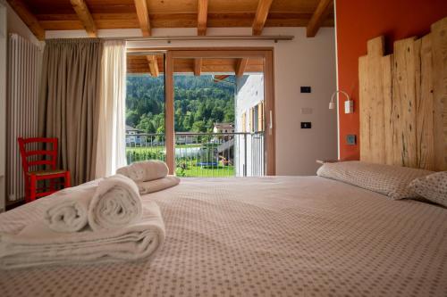 - une chambre avec un grand lit et une grande fenêtre dans l'établissement La Lesivèra Bed and Breakfast, à Tione di Trento