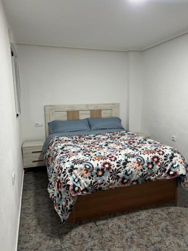 1 dormitorio con 1 cama con colcha de flores en Lovely rooms near the metro en Paterna