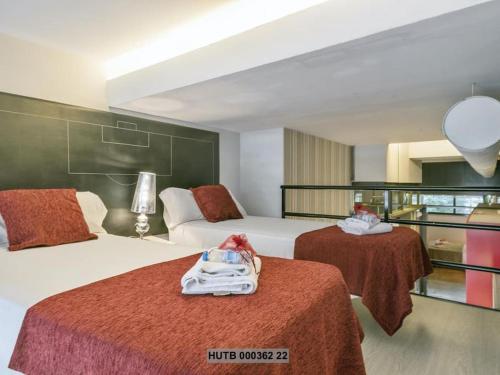 a hotel room with two beds with red sheets at Alcam Futbol Pequeño in Barcelona