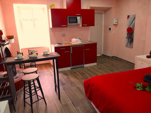 a kitchen with red cabinets and a table in a room at IL NIDO Suite in Fiuggi