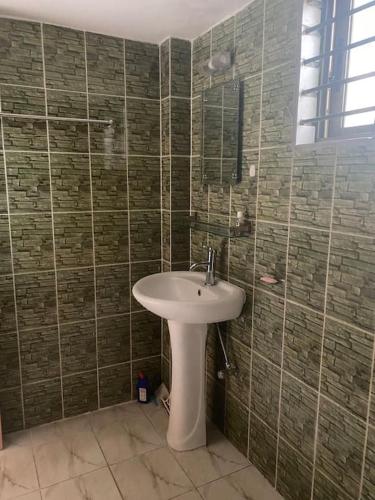 W łazience znajduje się biała umywalka i prysznic. w obiekcie Holiday Home in Khastobir Sylhet Town w mieście Srihotto