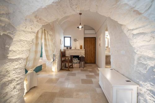 een woonkamer met een stenen muur en een tafel bij Valle D'Itria Trulli e Alcova Mikael in Cisternino