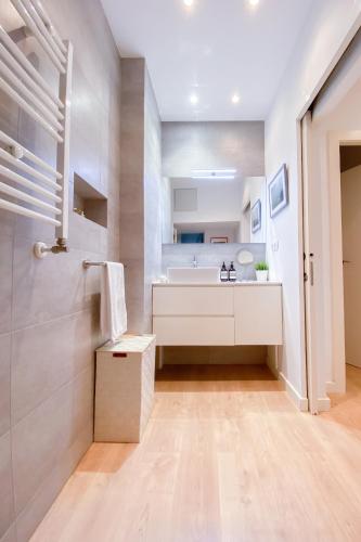 a white bathroom with a sink and a shower at Anna & Thomas - Sitges Center Apt in Sitges