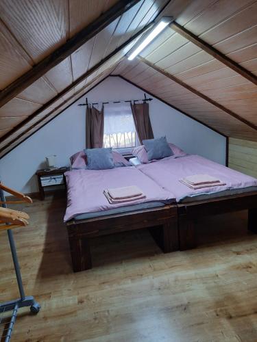 a bedroom with a large bed in an attic at Chata Pohodička in Banský Studenec