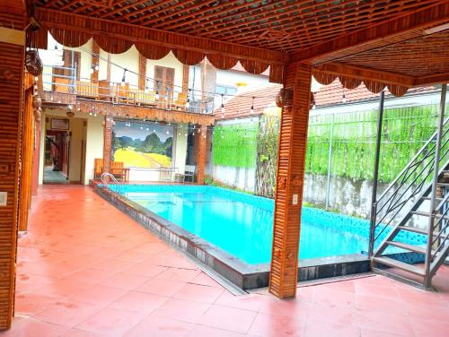 una gran piscina en un edificio con balcón en Chu Thuong Bungalow en Ninh Binh