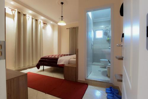y baño con cama, ducha y aseo. en Hotel Restorant Halal Il Tramonto., en Vorë