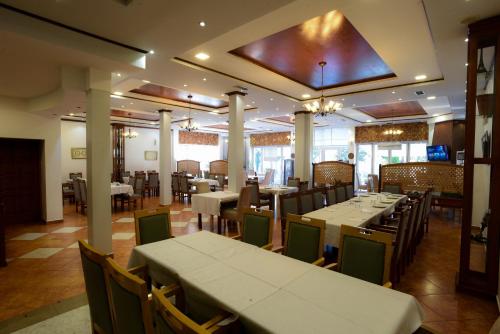 a dining room with tables and chairs in a restaurant at Hotel Restorant Halal Il Tramonto. in Vorë
