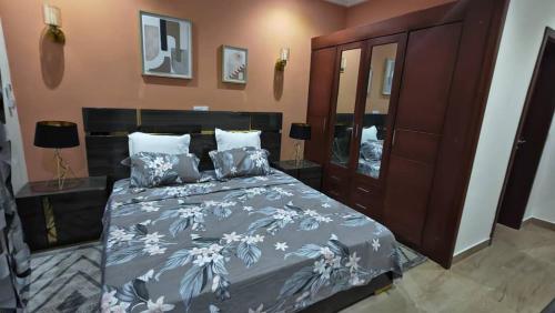 1 dormitorio con 1 cama con colcha azul y blanca en Résidence Axel en Pointe-Noire