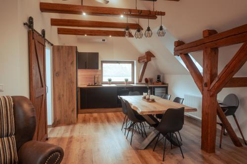 a kitchen and dining room with a wooden table and chairs at Apartmán Rustikal in Trstěnice