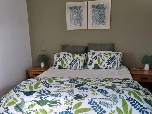 a bedroom with a bed with blue and white sheets and pillows at Karoo Nest - Calitzdorp in Calitzdorp