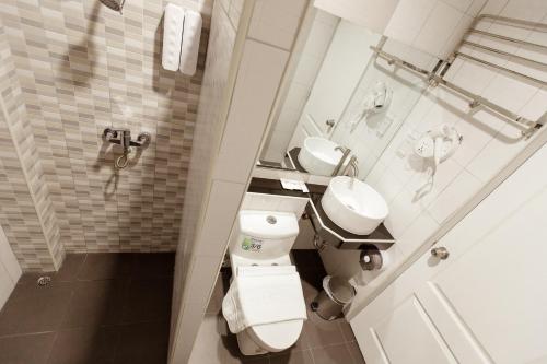 a bathroom with a toilet and a sink at Ioon Resort ไออุ่นรีสอร์ท in Sara Buri