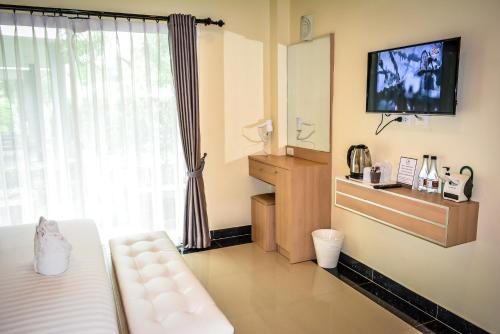 a room with a bed and a tv and a window at Ioon Resort ไออุ่นรีสอร์ท in Sara Buri