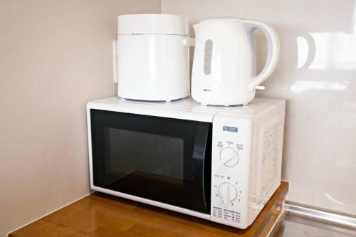 a microwave with two coffee cups on top of it at TOMMY CONDOMINIUM WAKASA402 in Kume