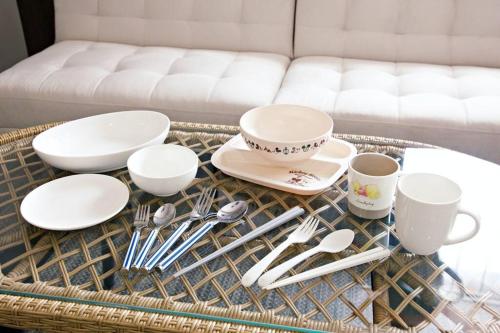 a table with plates and utensils on a table at TOMMY CONDOMINIUM WAKASA402 in Kume