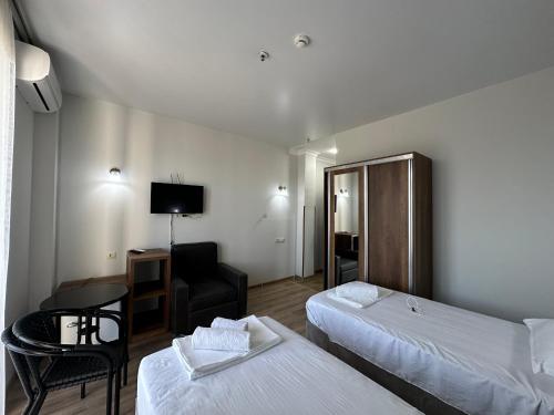 a hotel room with two beds and a chair at Majestic in K'obulet'i