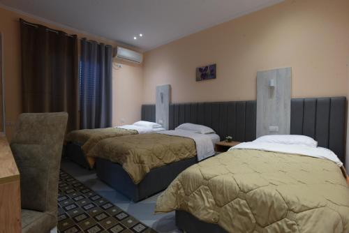 a hotel room with three beds and a chair at Hotel Restorant Halal Il Tramonto. in Vorë