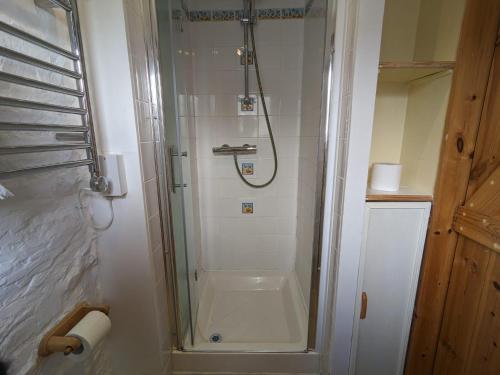 a shower with a glass door in a bathroom at Immaculate 1-Bed Cottage in Bideford in Bideford
